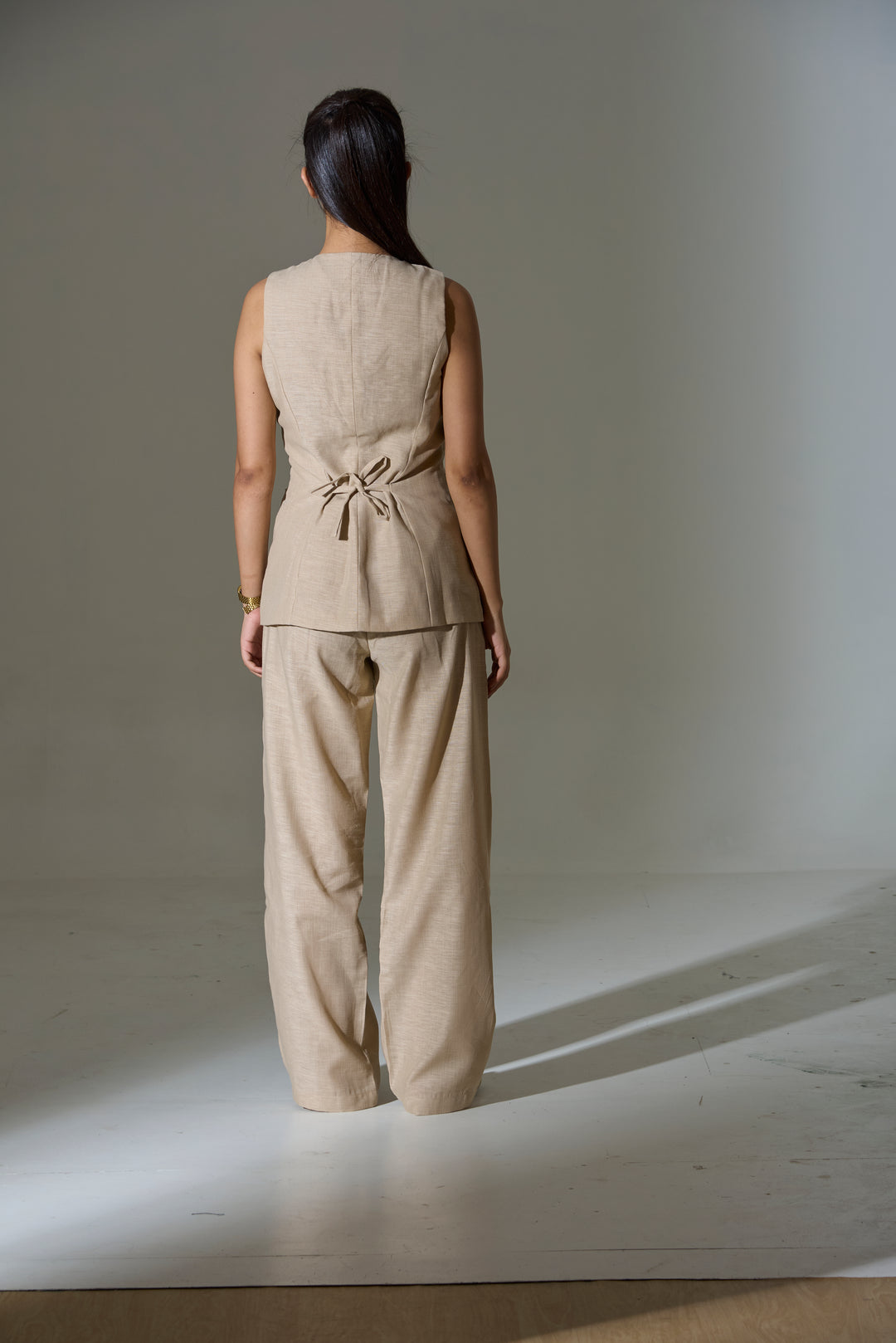 Model wearing a beige sleeveless V neck Waist coat and pants