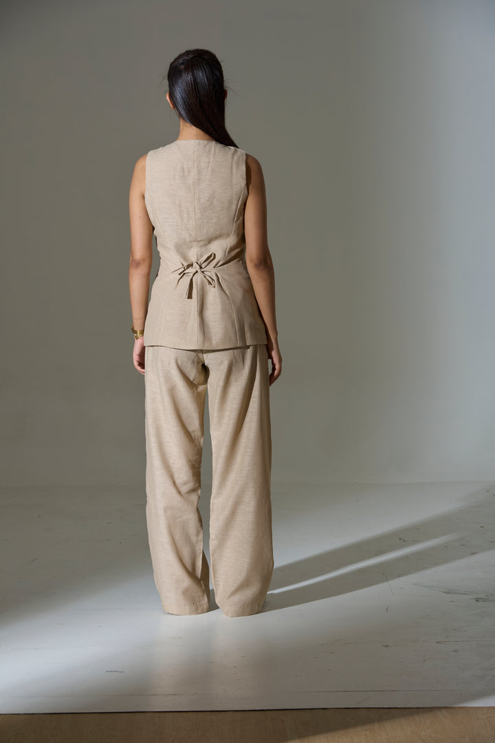 Model wearing a beige sleeveless V neck Waist coat and pants