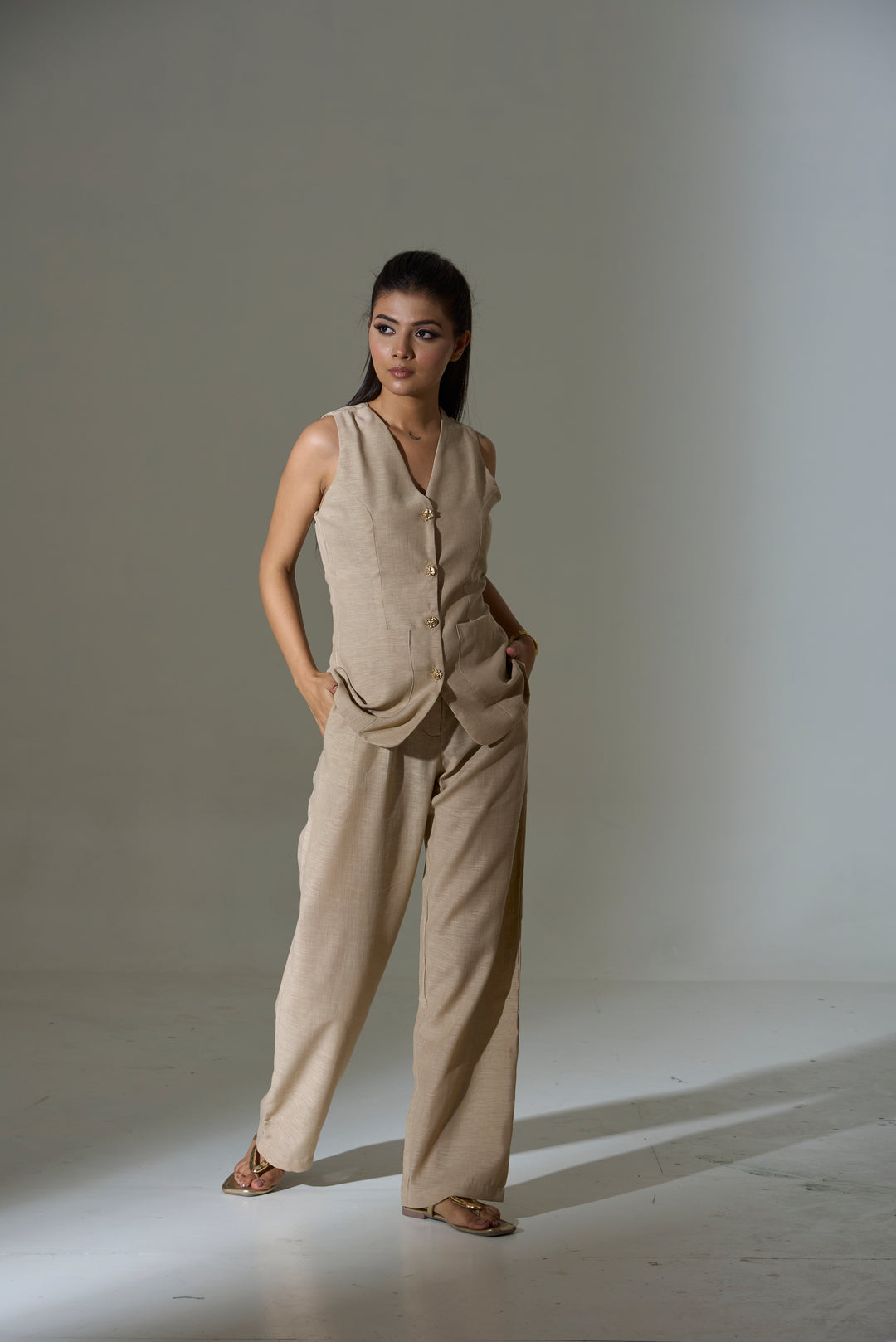 Model wearing a beige sleeveless V neck Waist coat and pants