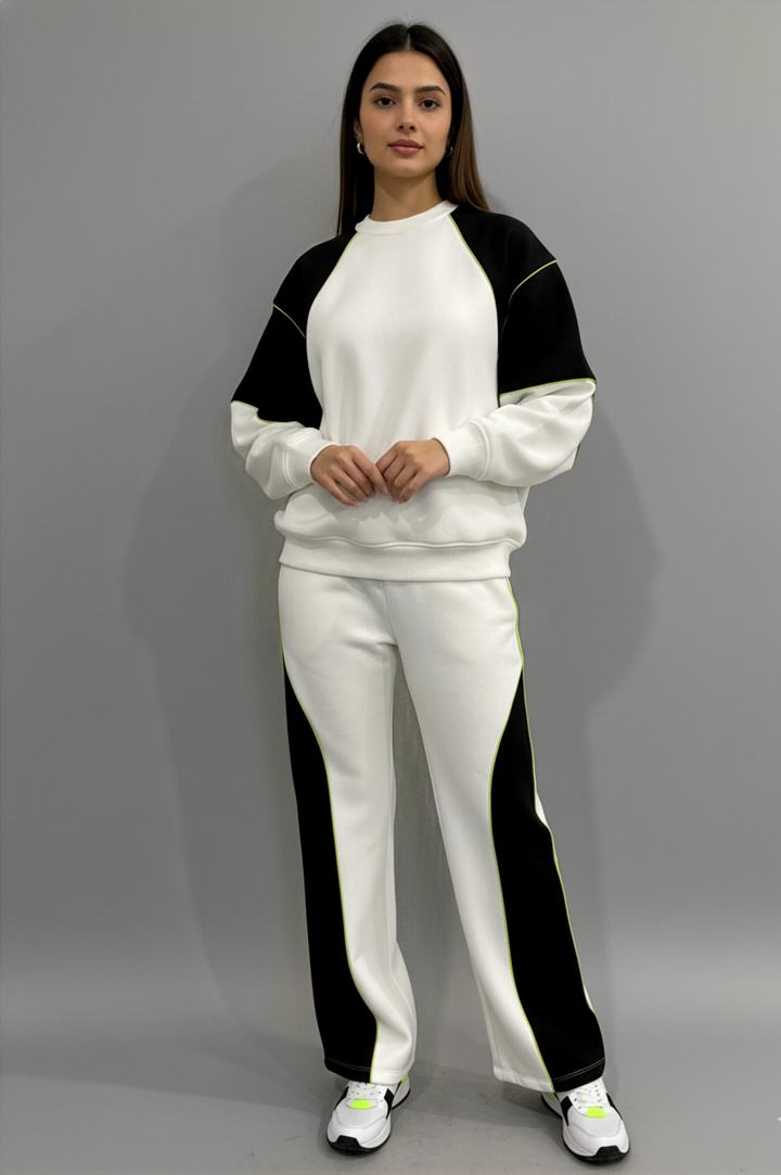 Person wearing a black and white tracksuit on a gray background