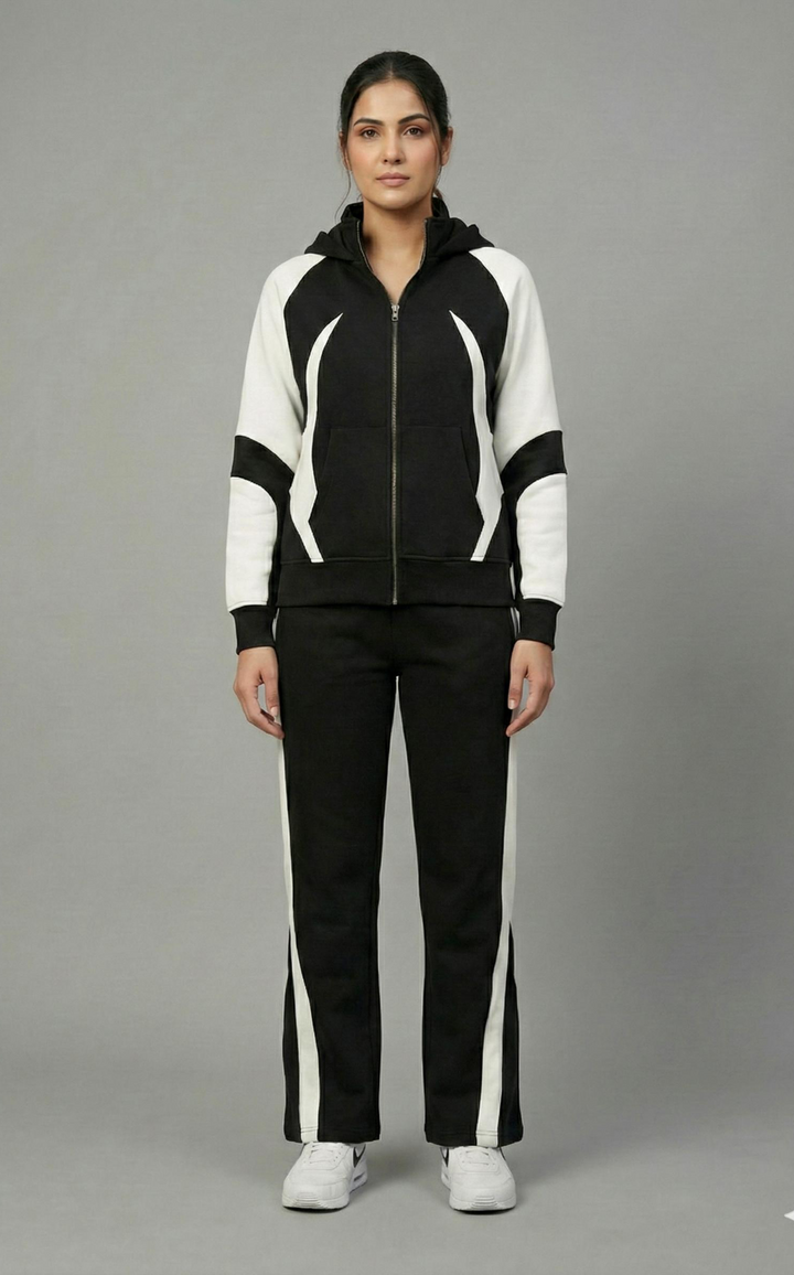 Woman wearing a black and white tracksuit on a gray background