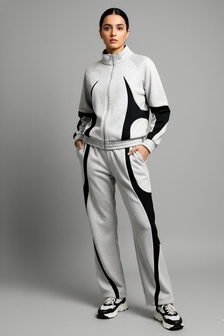 Person wearing a gray tracksuit with black accents on a gray background