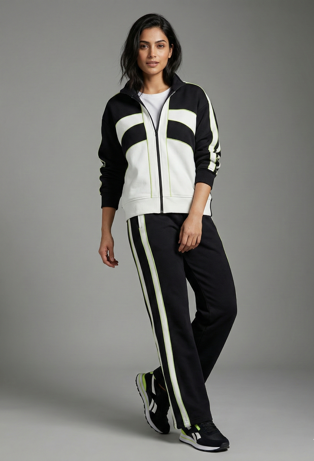 Woman wearing a black and white tracksuit on a gray background