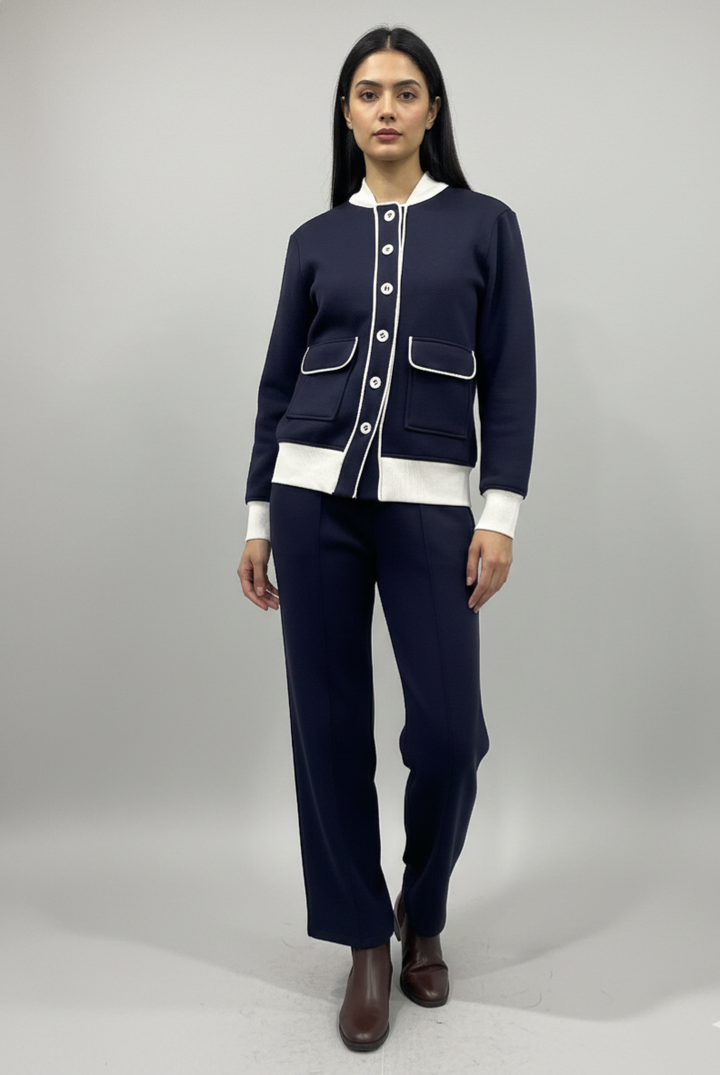 Woman wearing a navy blue outfit with white accents on a gray background
