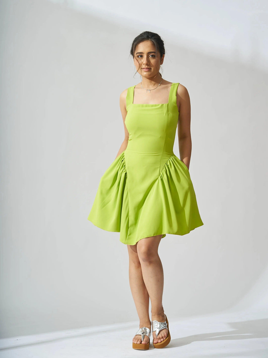 Risate backless bow mini dress in vibrant green with a flared skirt and adjustable straps