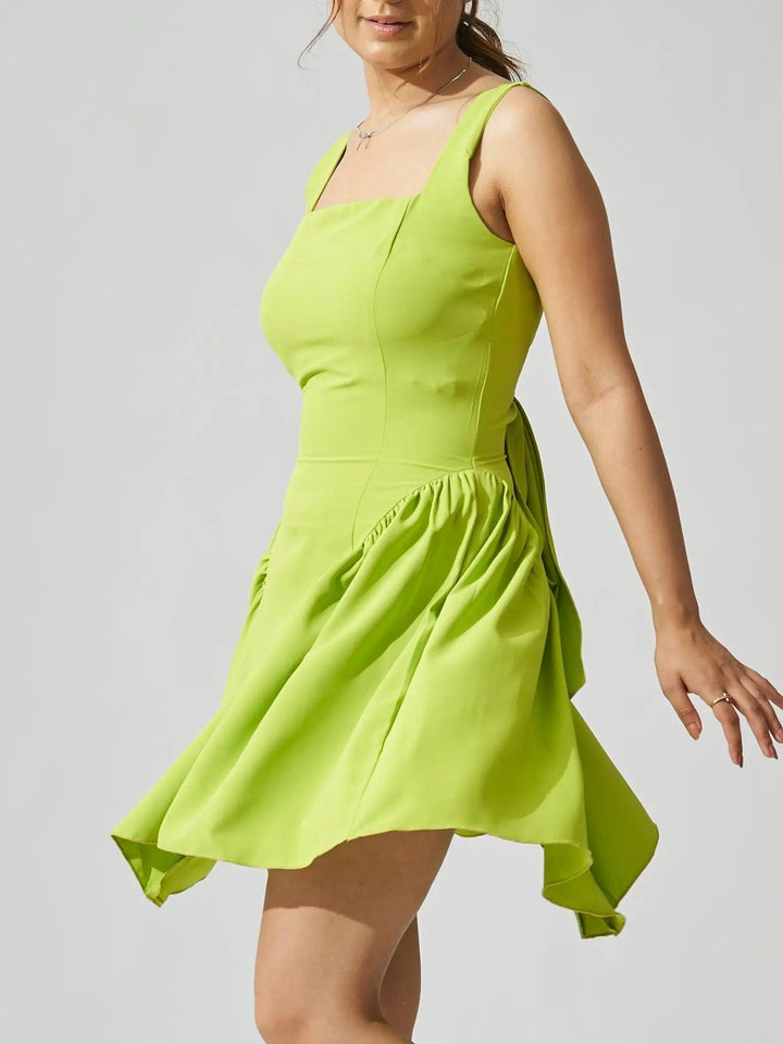 Risate backless bow mini dress in vibrant green with playful flared hem and elegant silhouette