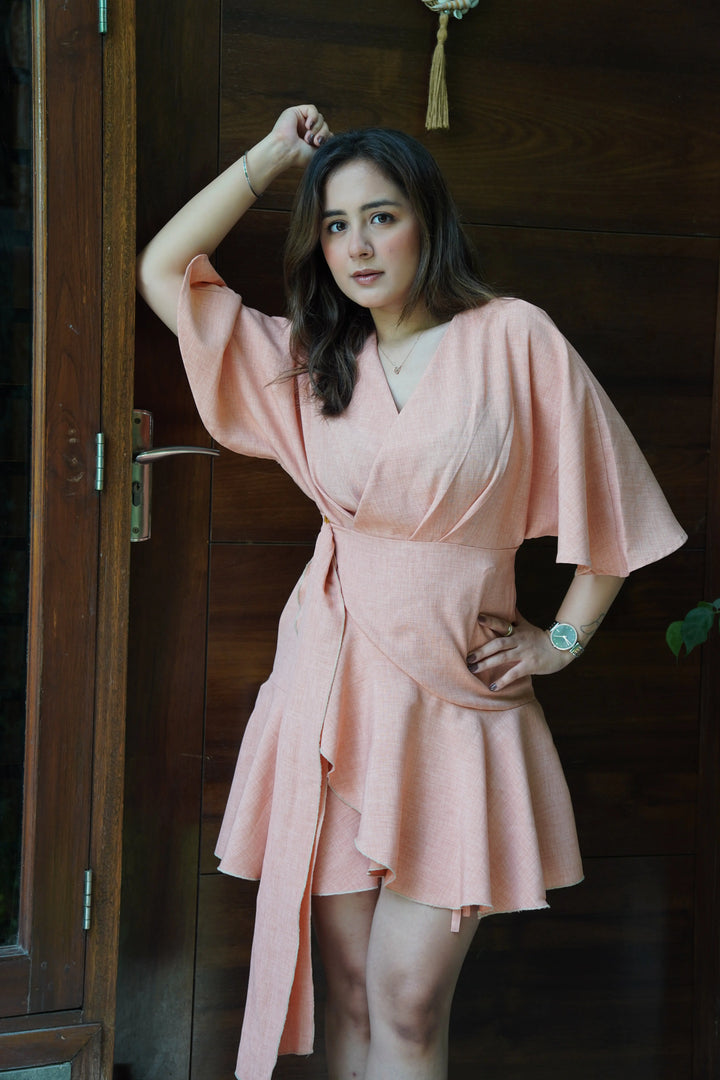 Risate blaze dress for women in soft peach with flared sleeves and an elegant wrap design