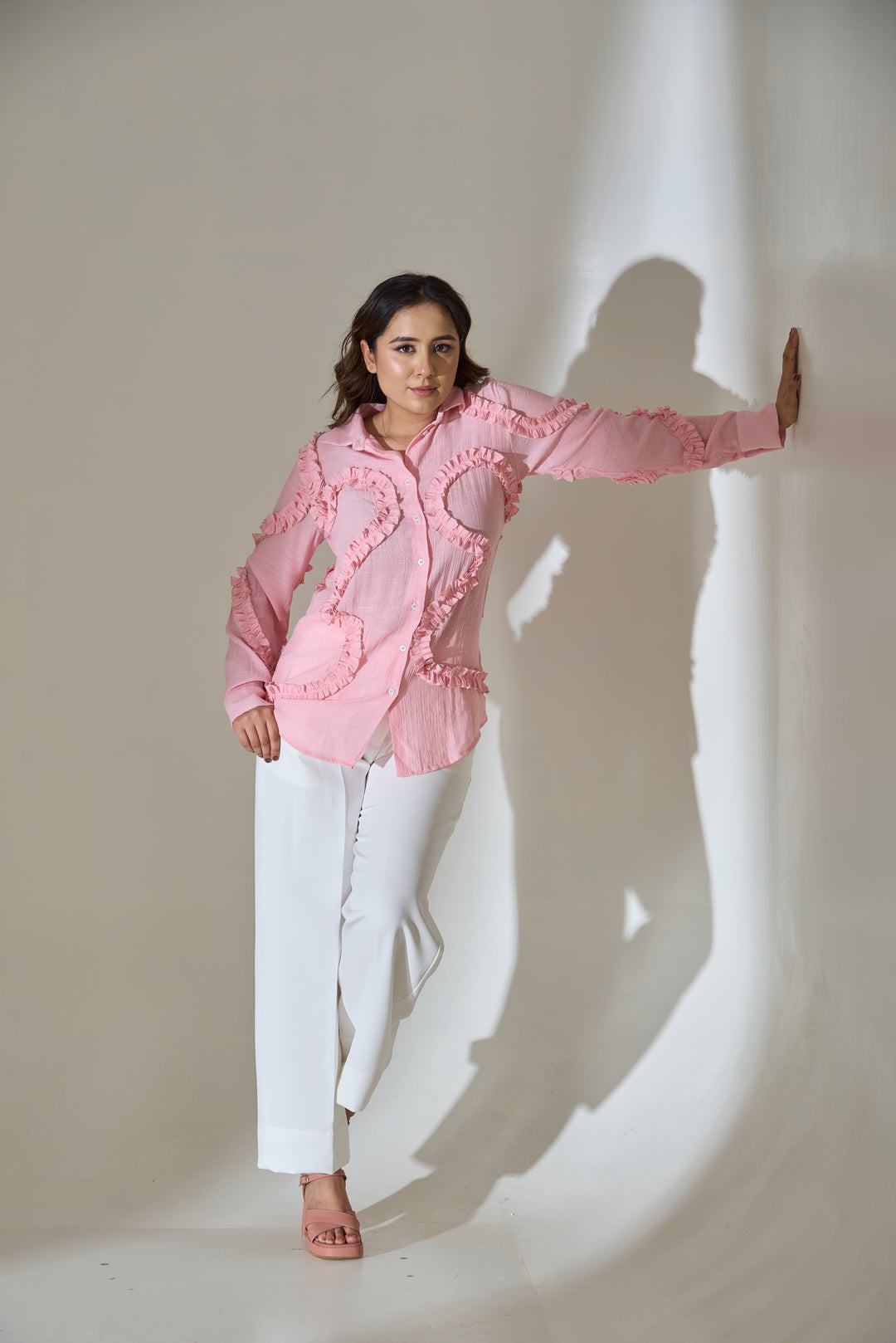 Risate blush pink ruffle linen blend shirt showcased with stylish white trousers