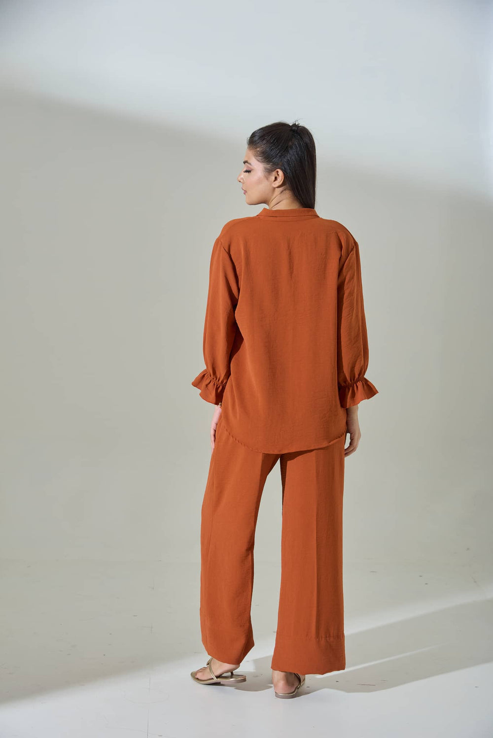 Woman wearing a burnt orange crepe coord set with a relaxed fit and stylish sleeves