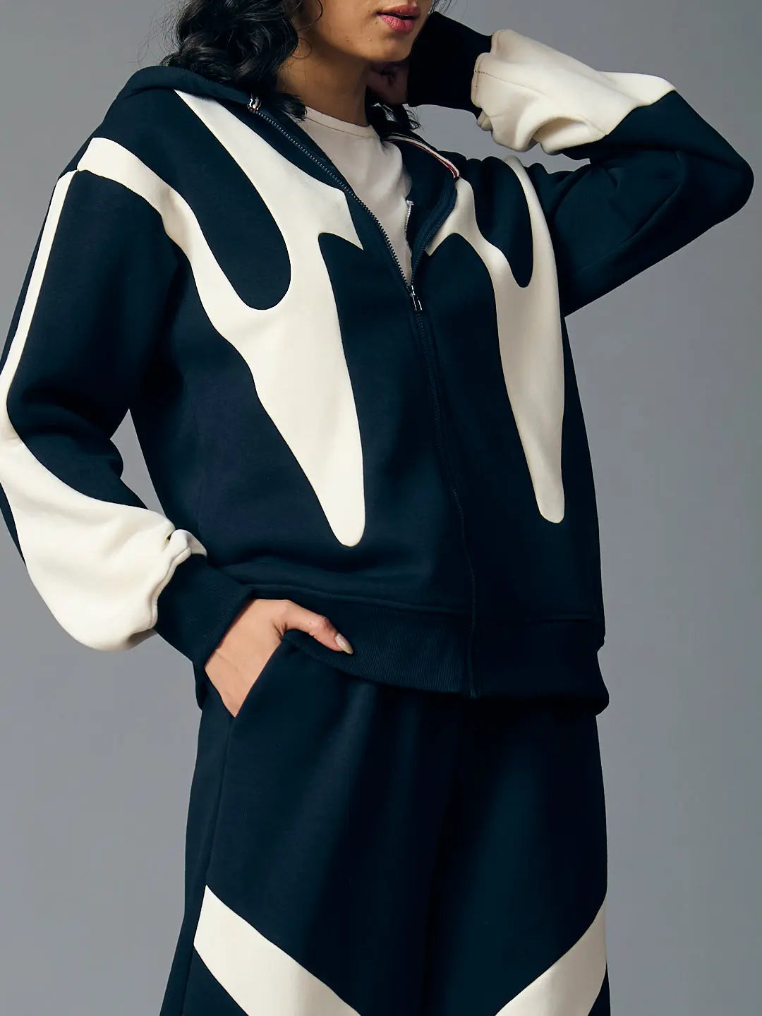 Risate chic streetwear set for women featuring a stylish black and cream zip-up hoodie and matching bottoms