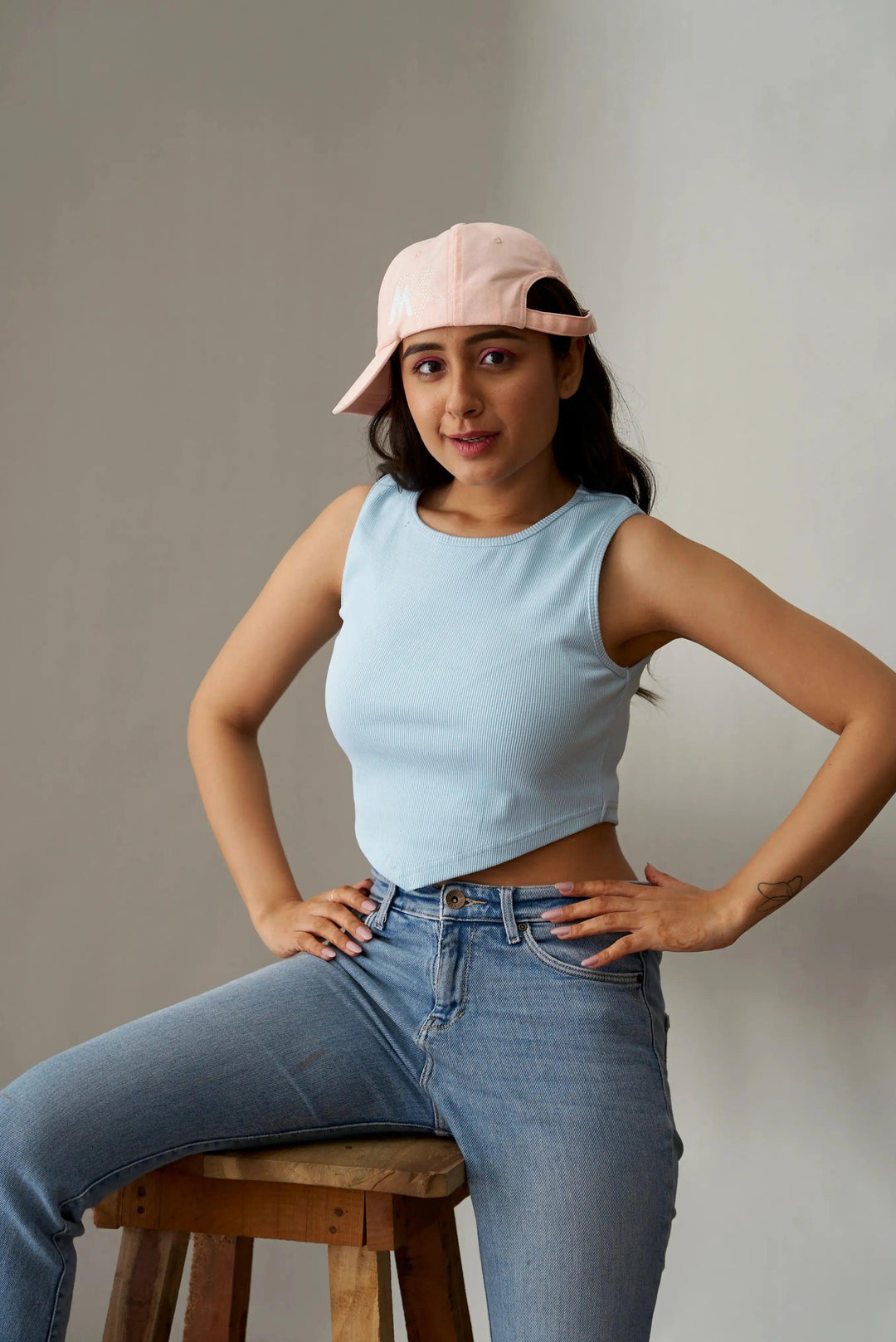 Light blue clover crop top for women styled with high-waisted jeans and a pink cap