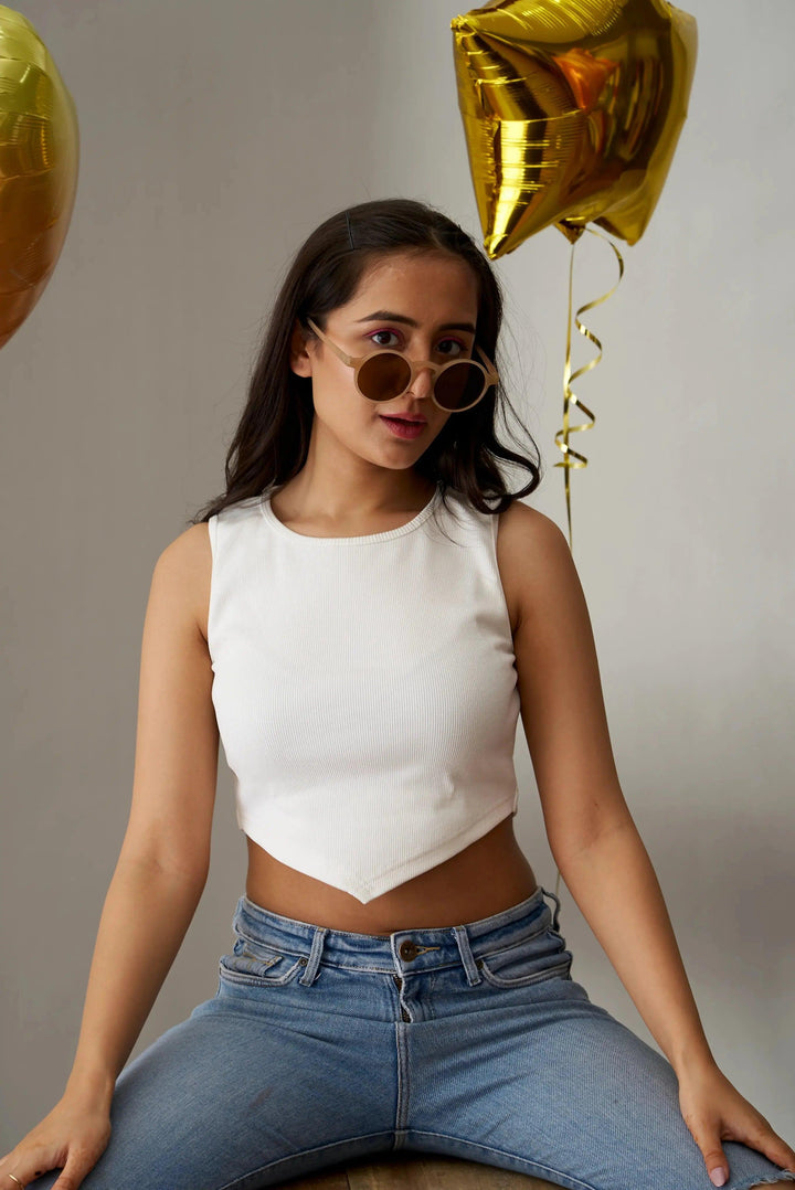 White clover crop top for women styled with high-waisted jeans and sunglasses against a festive backdrop