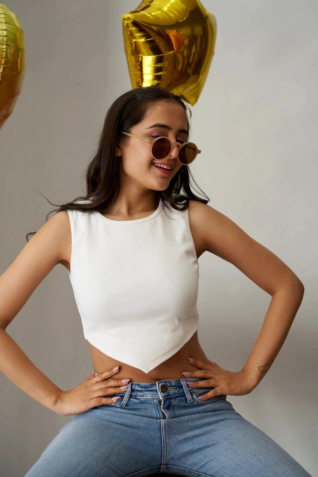 Chic white clover crop top for women paired with high-waisted jeans and stylish sunglasses
