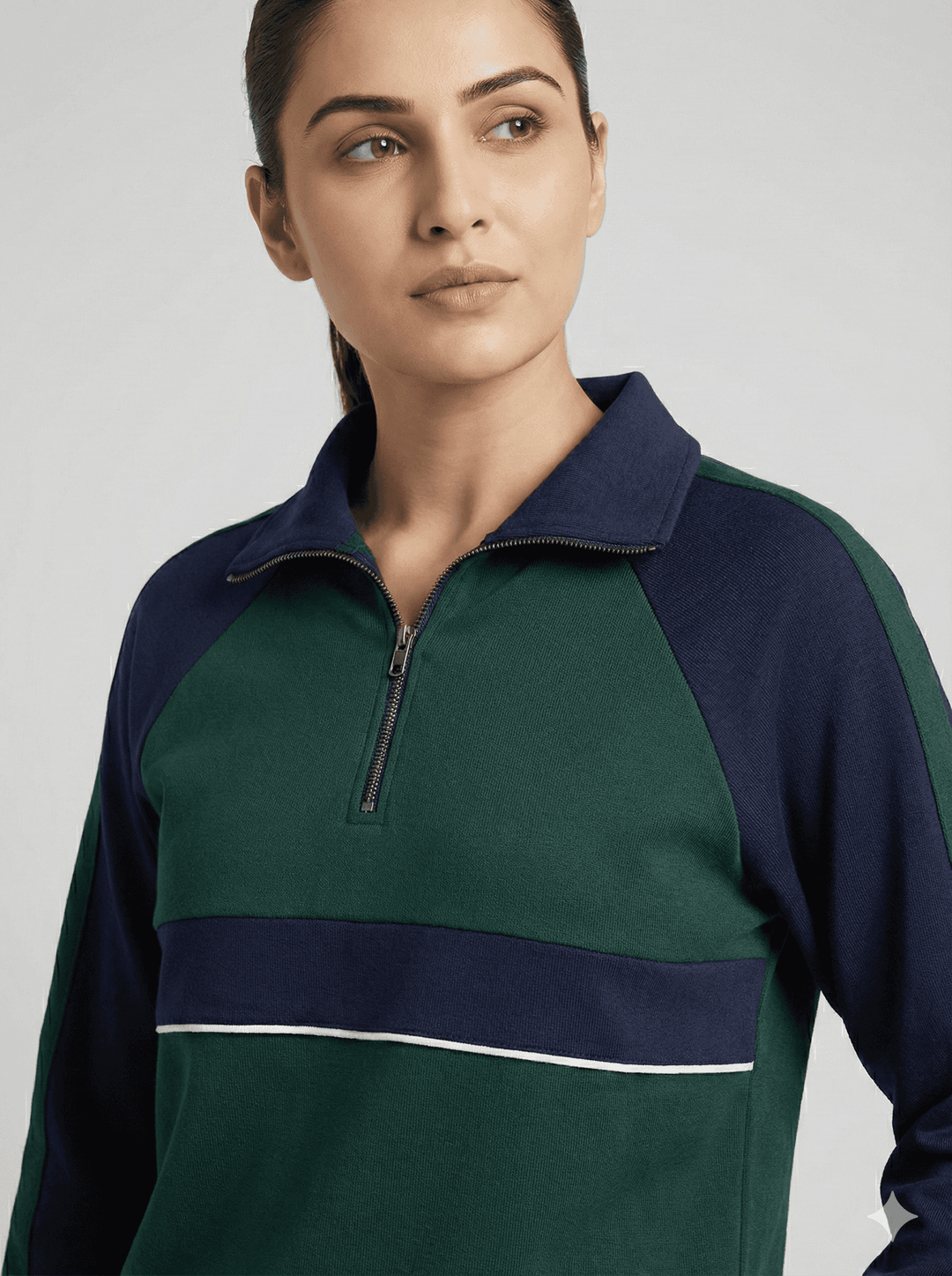 Woman modeling emerald navy luxe trackset for women with zip-up collar and stylish color blocking.