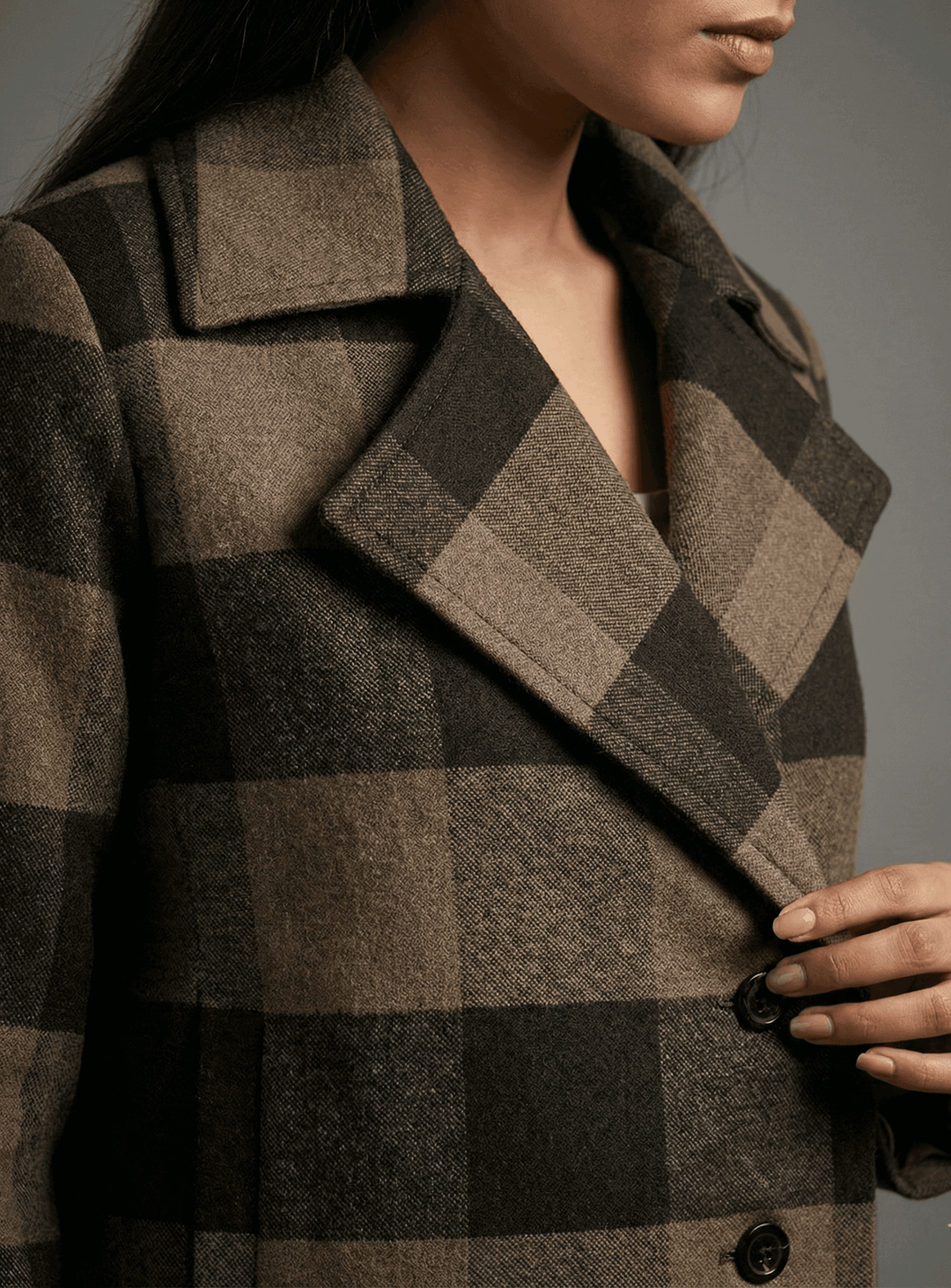 Female model wearing an espresso checkered cropped jacket with a stylish collar and buttons