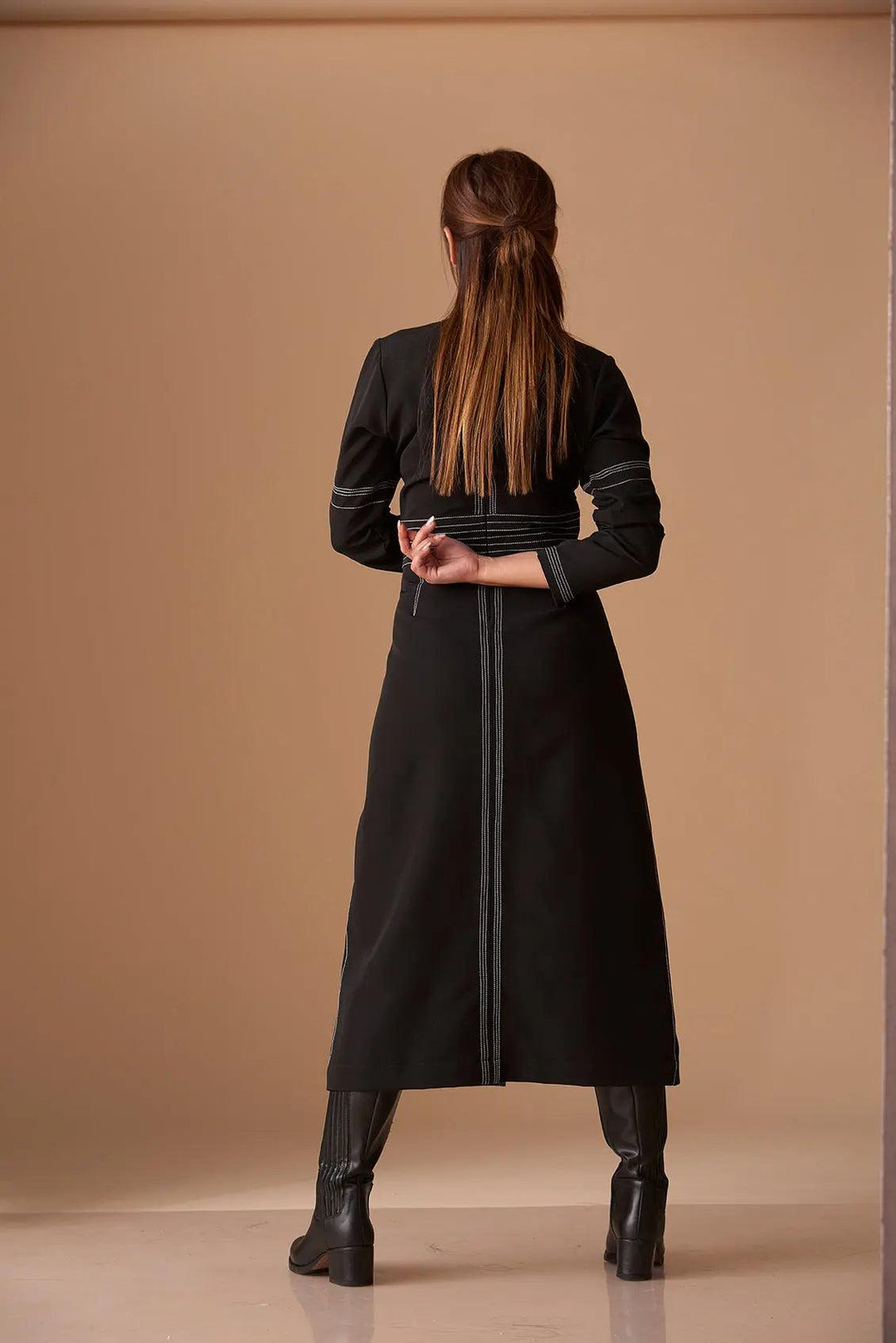 Back view of a black long sleeve mock neck dress for women designed by Risate featuring a flattering fit