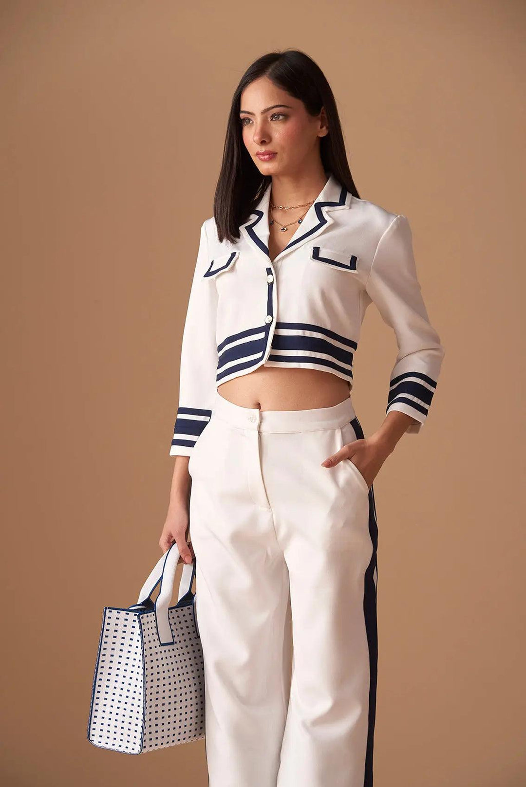 Stylish white cropped jacket with navy stripes, paired with matching pants for a chic look