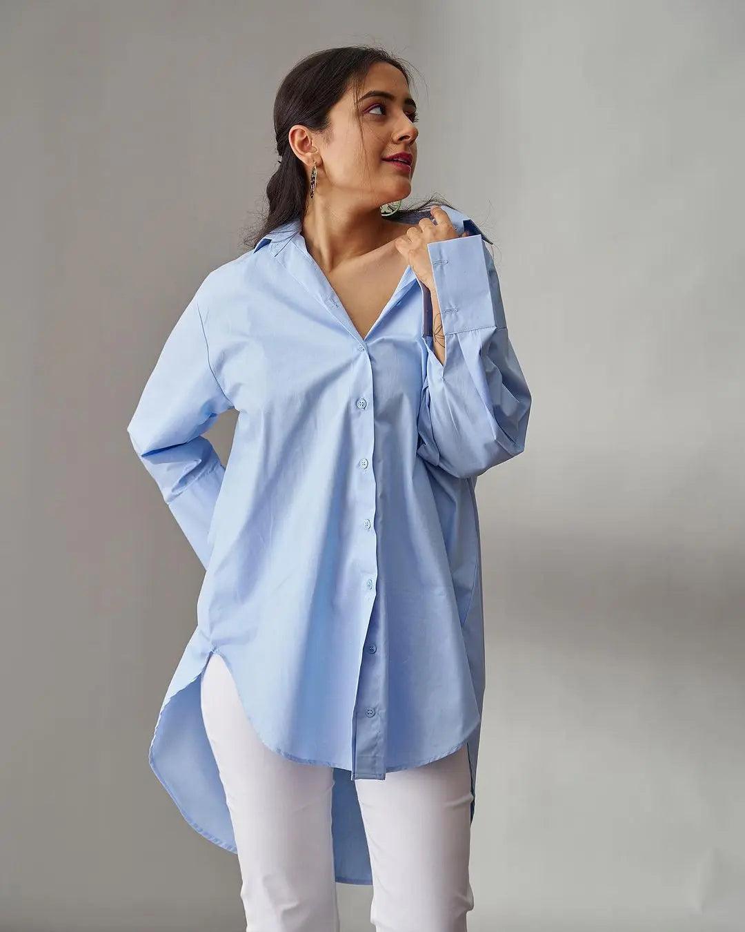Light blue oversized poplin shirt for women styled with button-down front and high-low hem