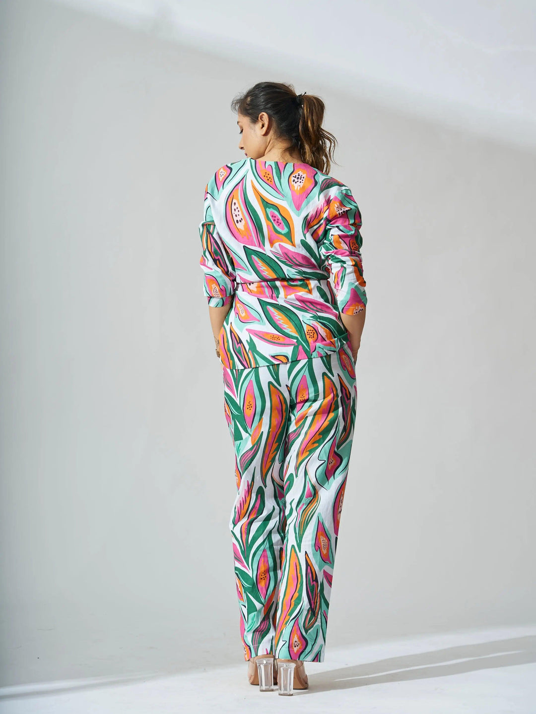 Back view of a woman in a vibrant papaya print linen coord set from Risate