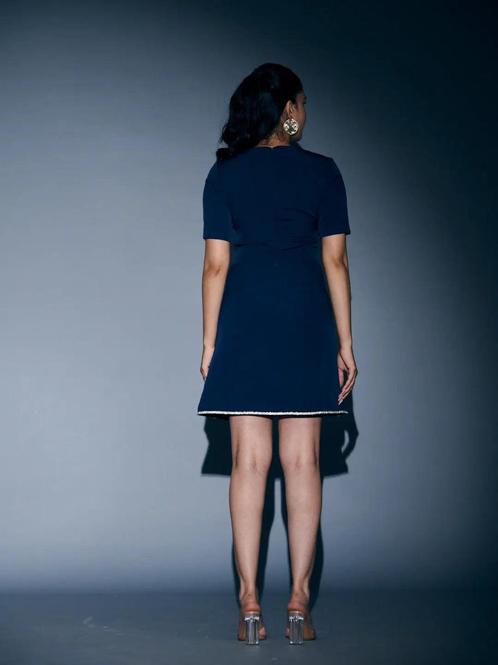 Back view of a Risate rhinestone lace mini dress with a fitted style and elegant detailing