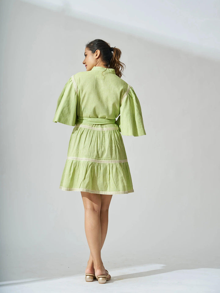 Back view of a light green ruffle linen blend mini dress with balloon sleeves and a cinched waist