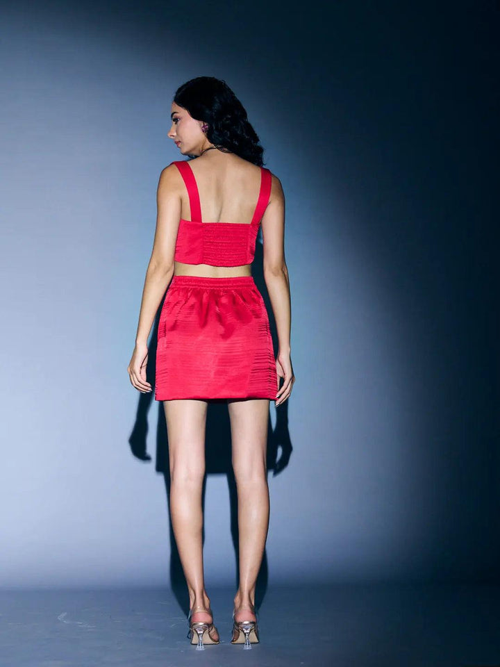 Back view of a woman wearing a Risate satin blazer skirt set for women in vibrant red