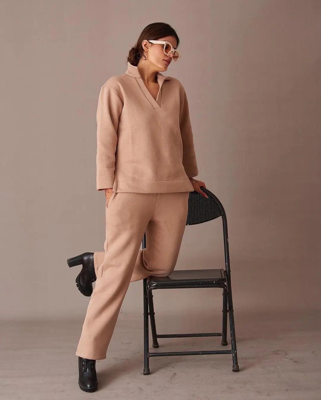 Risate ugly christmas pullover co-ord set in beige, featuring soft fabric and relaxed fit, posed stylishly by a chair