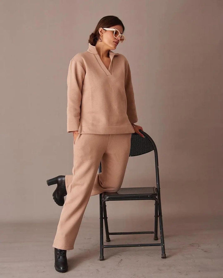 Risate ugly christmas pullover co-ord set in beige, featuring soft fabric and relaxed fit, posed stylishly by a chair