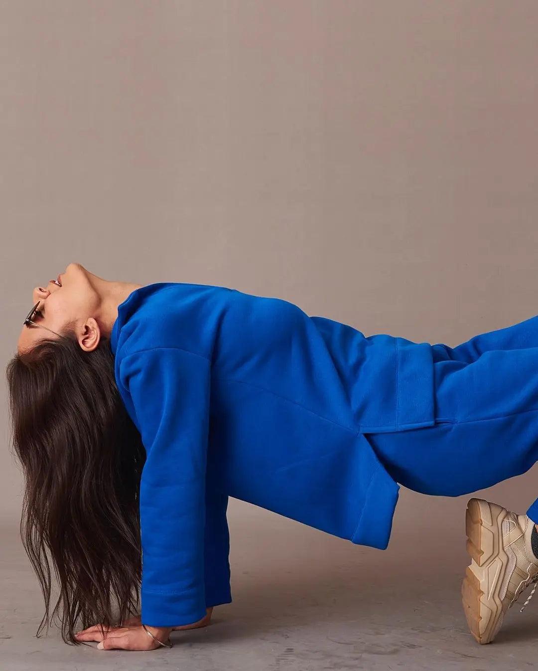 Risate blue co-ord set with an ugly christmas pullover style, model posed in a stylish push-up position