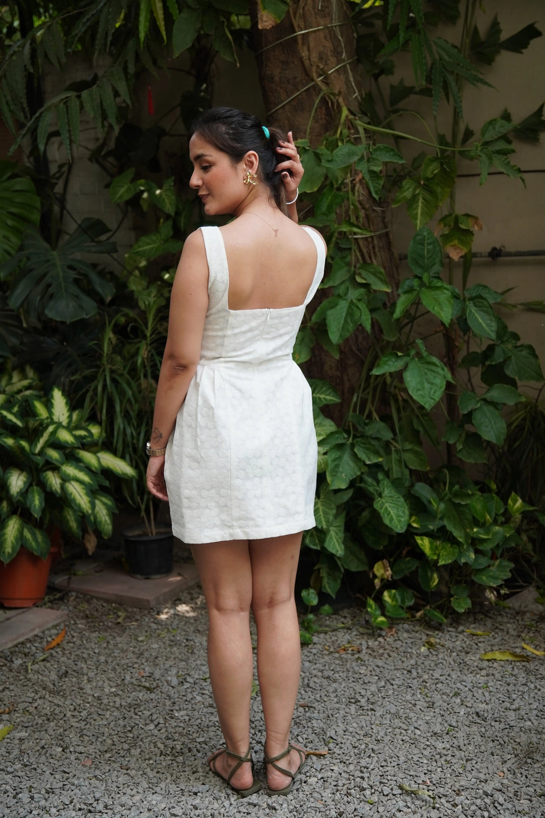 Back view of a woman wearing a white western dress for women with a fitted design and a playful flair