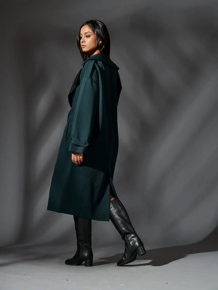 Risate women's classic trench coat in dark green, styled with knee-high black boots for a chic look