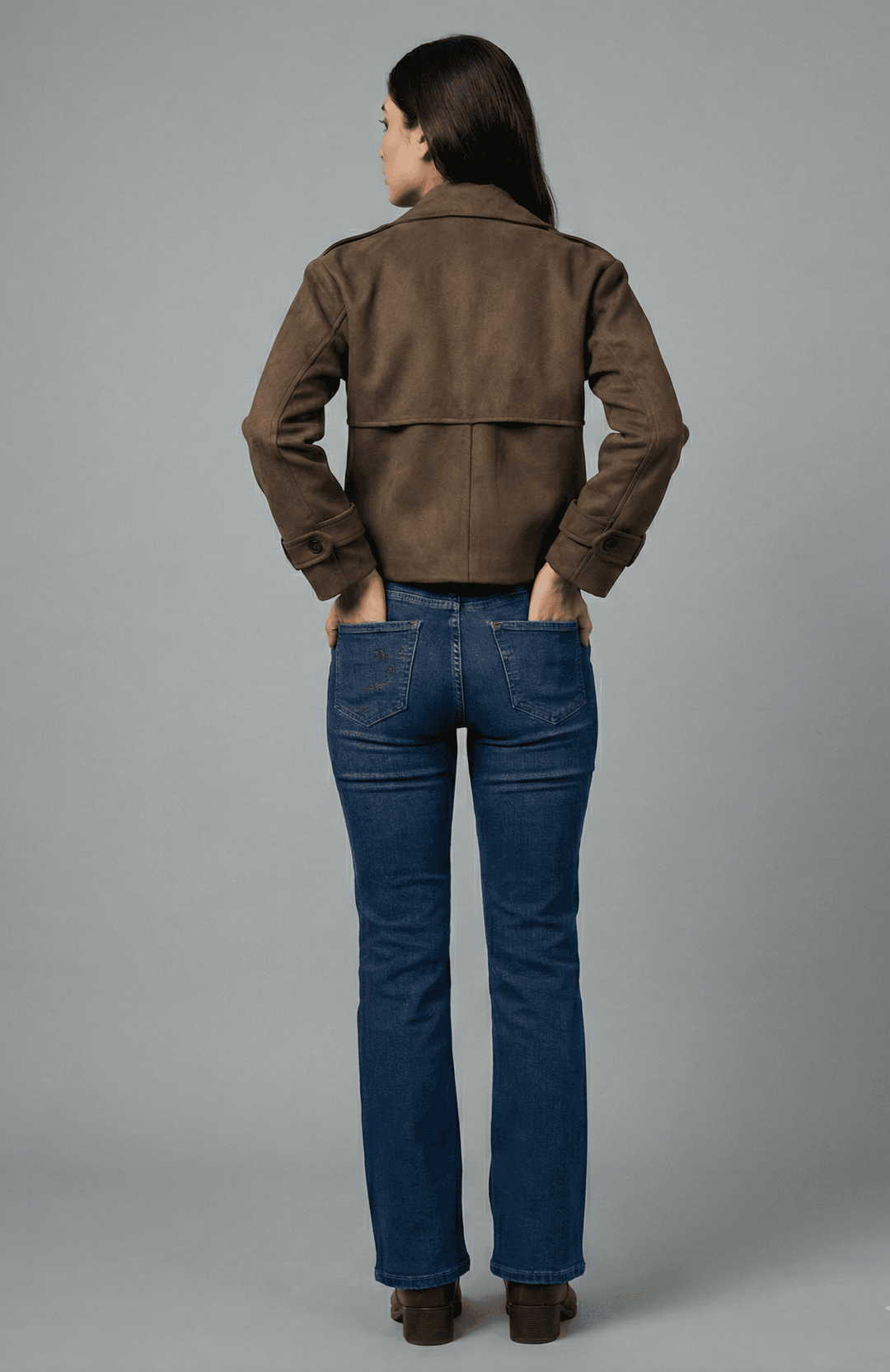 Back view of women's cocoa faux suede leather jacket paired with blue jeans for a stylish look