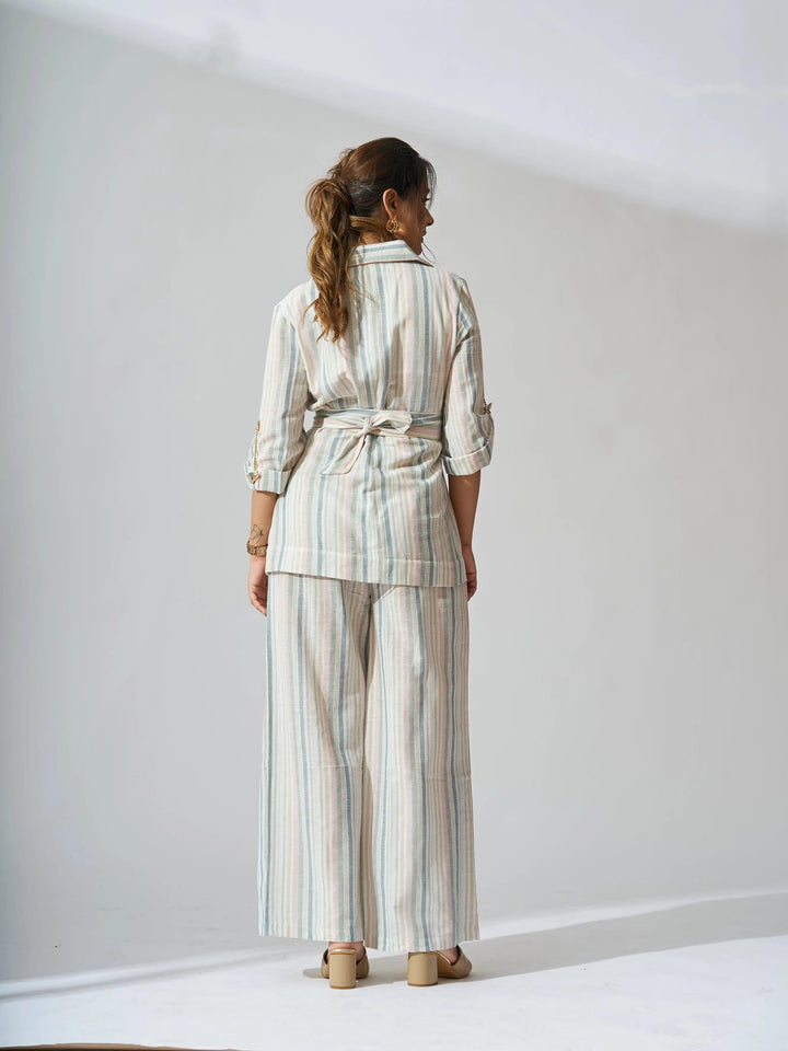 Back view of women's striped linen blazer set by Risate styled with wide-leg pants