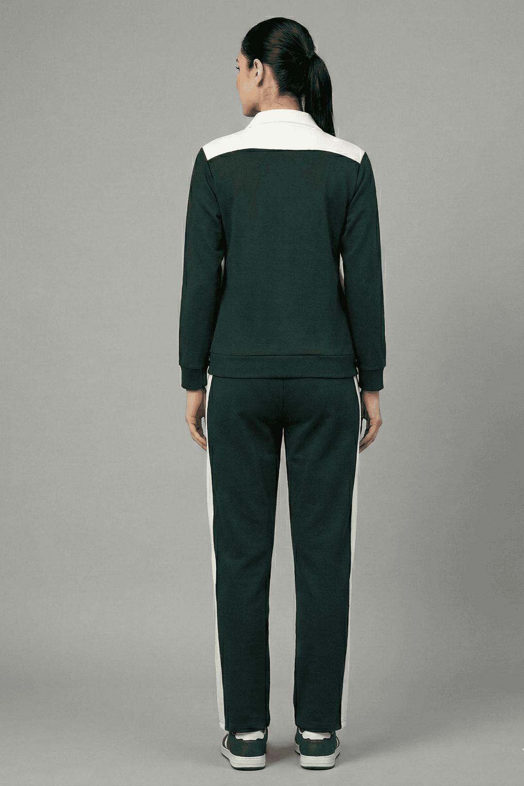 Back view of Risate women's tracksuit set in dark green with contrasting white stripes on sleeves and pants