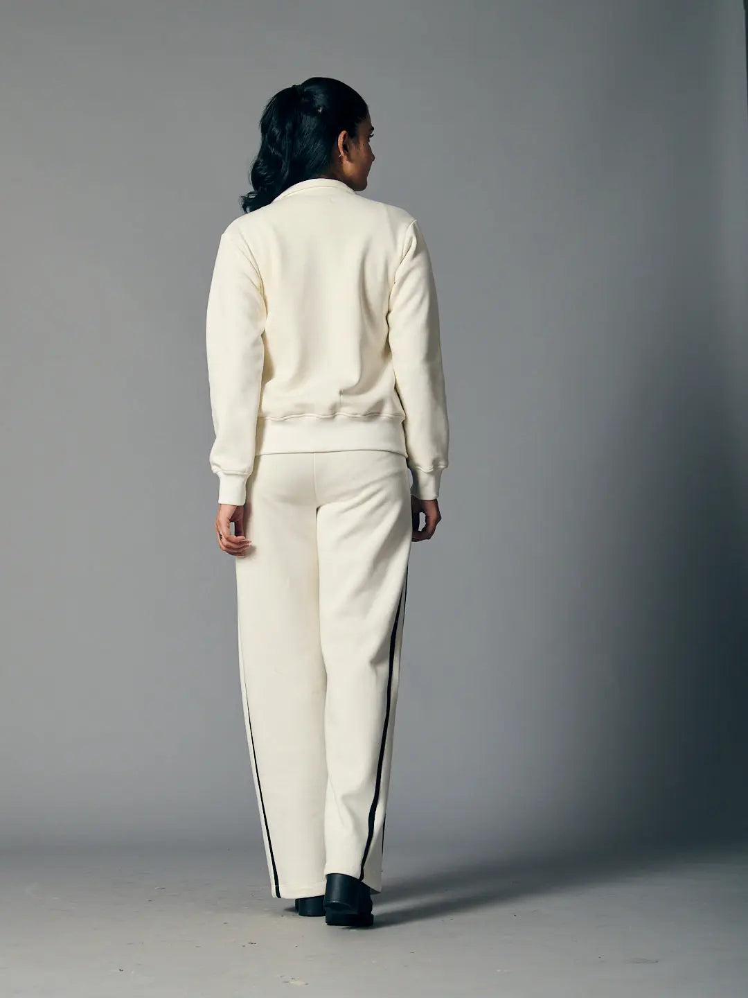 Women's zipper coord set in cream featuring a stylish back view with tapered pants and sporty stripes